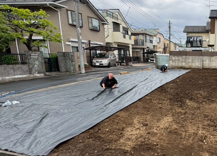 八王子椚田町の解体工事完了後に防草シートを施工している様子